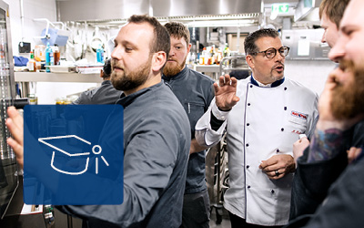 Chef istruisce il team accanto al forno professionale RATIONAL iCombi Pro.