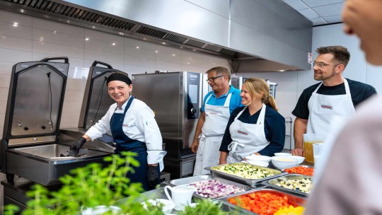 Kochteam bei Schulung mit RATIONAL iVario Pro und RATIONAL iCombi Pro Kombidämpfer in Profiküche.