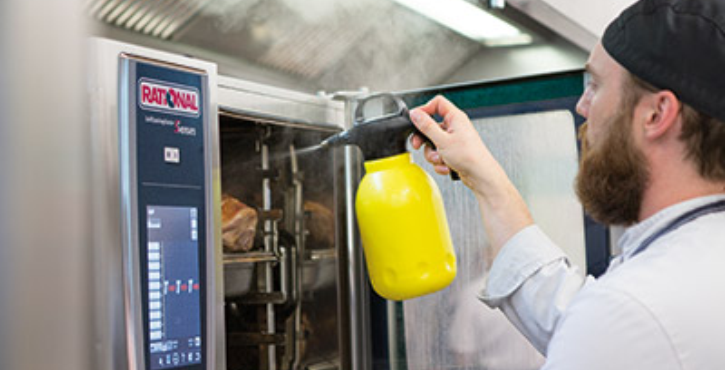 Chef spraying water in the SelfCookingCenter combi-steamer.