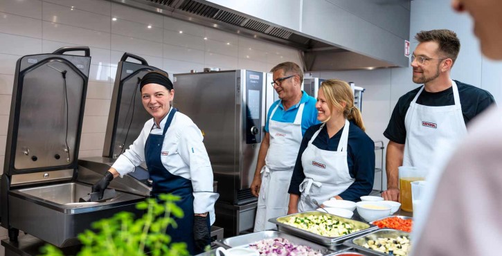 Kochteam bei Schulung mit RATIONAL iVario Pro und RATIONAL iCombi Pro Kombidämpfer in Profiküche.