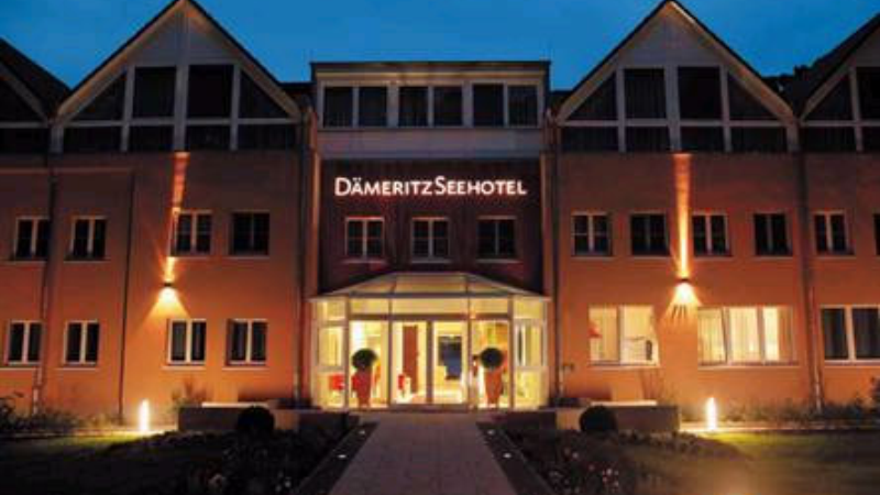 Front view of Dämeritz Seehotel illuminated at night.