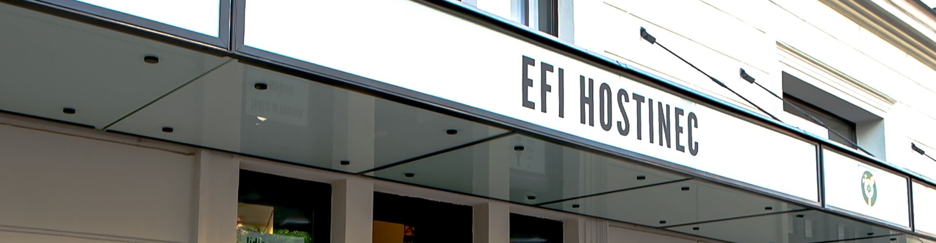Vnější pohled na restauraci EFI HOSTINEC s moderním skleněným přístřeškem.