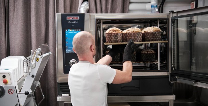 Bäcker entnimmt ein Blech mit Panettone aus dem RATIONAL iCombi Pro Kombidämpfer.