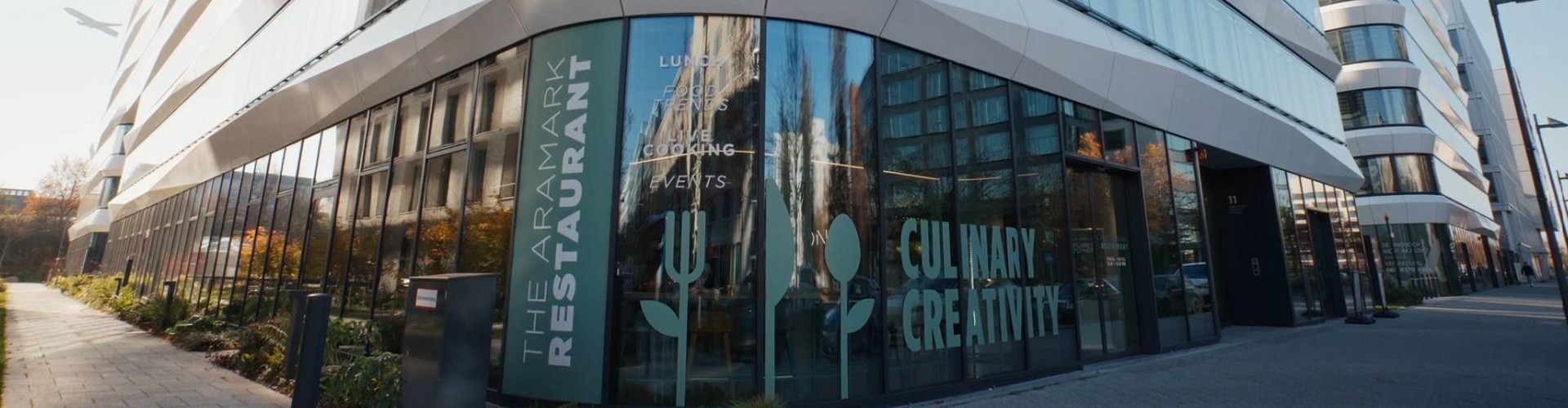 Modernes Bürogebäude mit Glasfassade und Aramark Restaurant im Erdgeschoss.