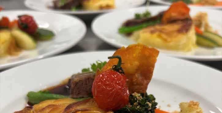 Rinderfilet mit glasiertem Gemüse und Kartoffelgratin in feiner Präsentation.
