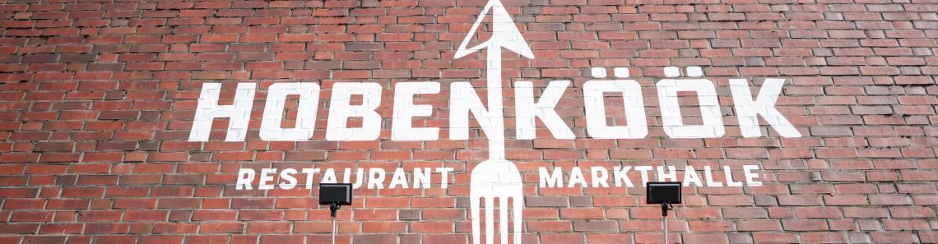 HOBENKÖÖK Restaurantschriftzug auf einer roten Backsteinwand.