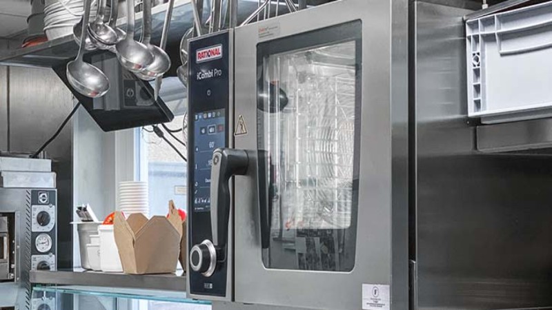 RATIONAL iCombi Pro Kombidämpfer in einer professionellen Küche mit hängenden Schöpfkellen.