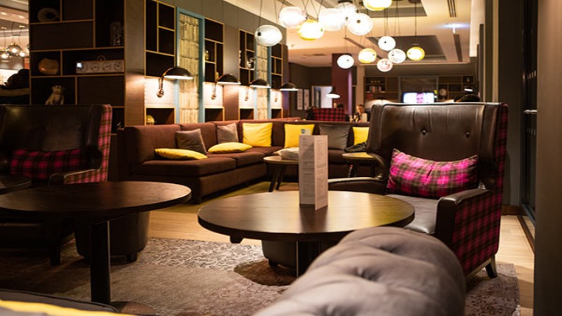 Moderne Hotellounge mit Sesseln, Sofas und warmer Ambientebeleuchtung.