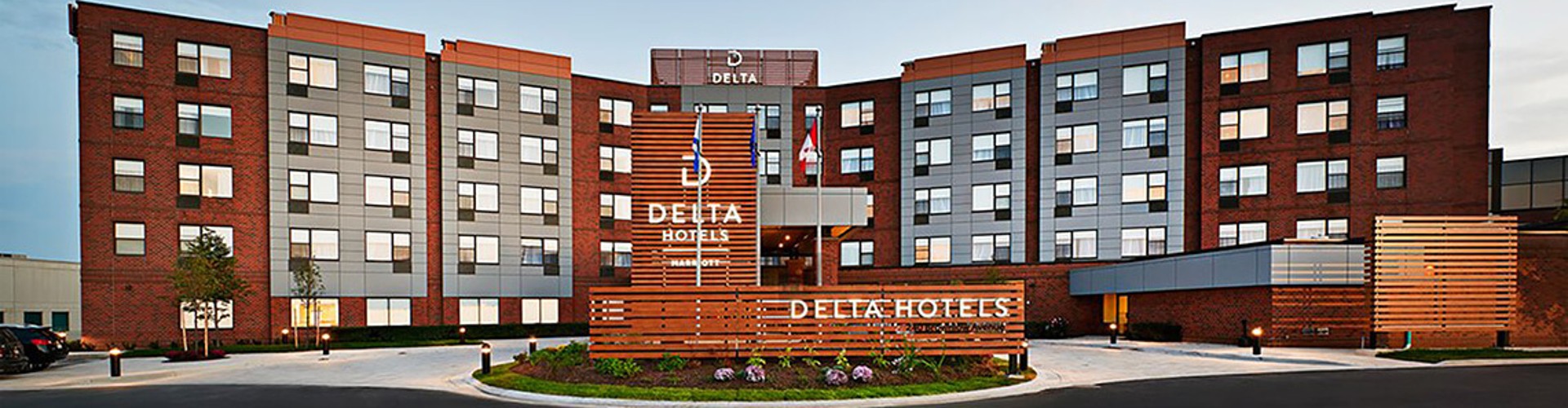 Delta Hotels building with modern design and a sign in front.