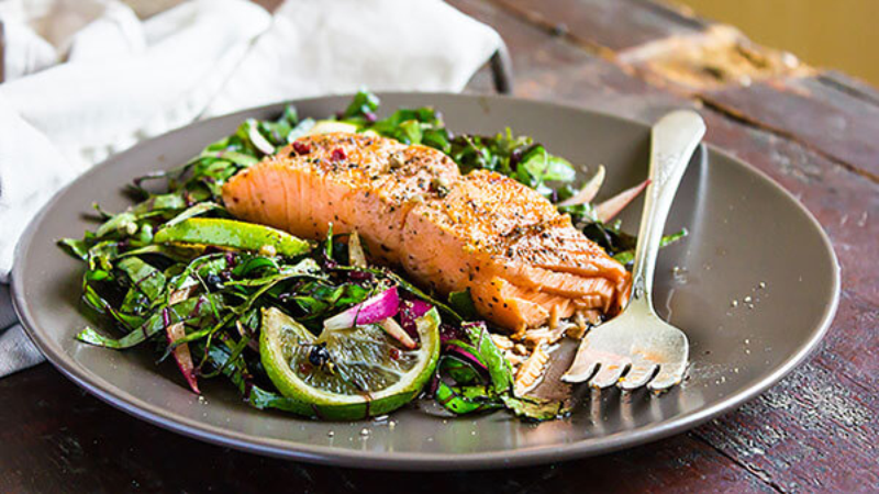A plate with grilled salmon and fresh salad.