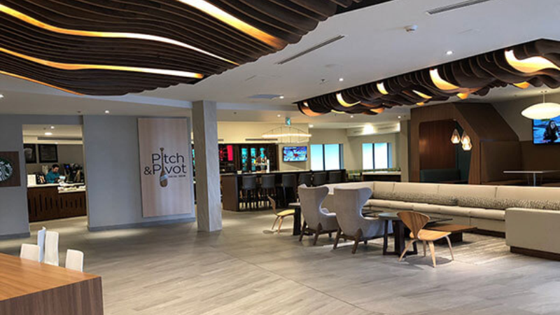 Modern hotel lobby with lounge seating and a bar area.