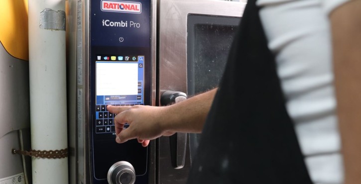 Operator using the touchscreen of the RATIONAL iCombi Pro combi oven.