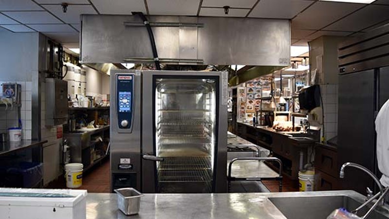 A professional kitchen with a Rational oven and stainless steel equipment.
