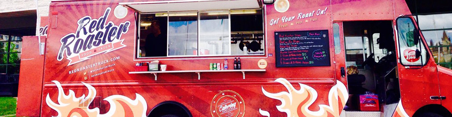 A food truck with the name ‘Red Roaster‘ on the side, displaying the menu and logo, and a vendor standing inside.