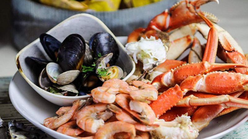 A plate of seafood including shrimp, crab legs, and mussels.