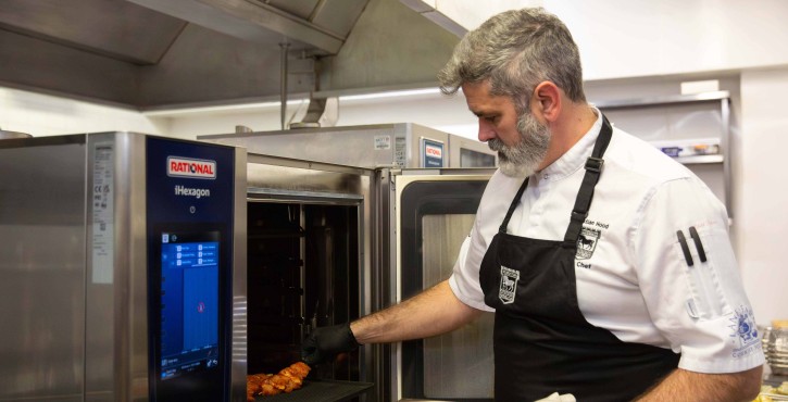 Christian Hood, Sous Chef at Ipswich Town Football Club, places some chicken skewers onto a grill tray in the iHexagon, ready to cook.