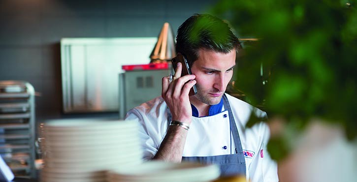 A concerned chef on the phone in the kitchen