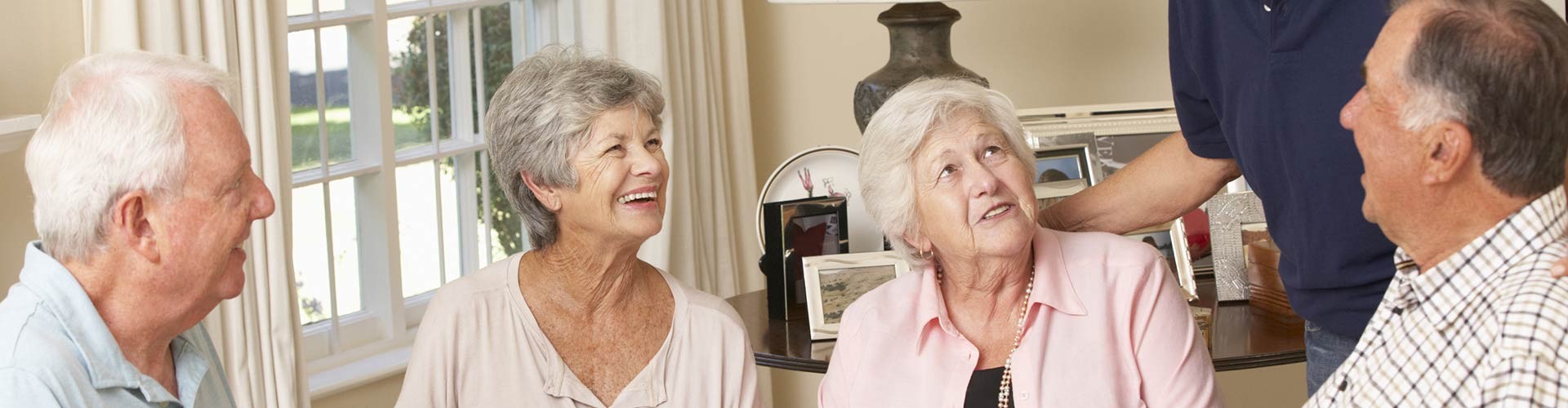 A group of older adults enjoying a conversation in a cozy indoor setting.