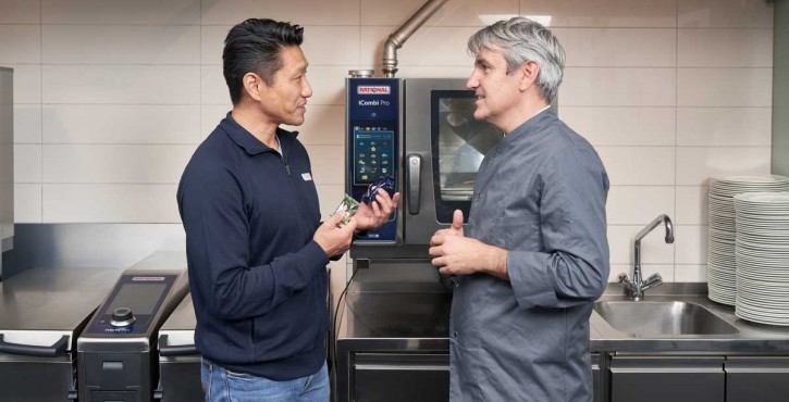 A RATIONAL representative talks to a chef about the cleaning tablets needed for the RATIONAL iCombi Pro.