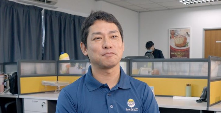 Beard Papa‘s employee seated in the company office wearing branded uniform.