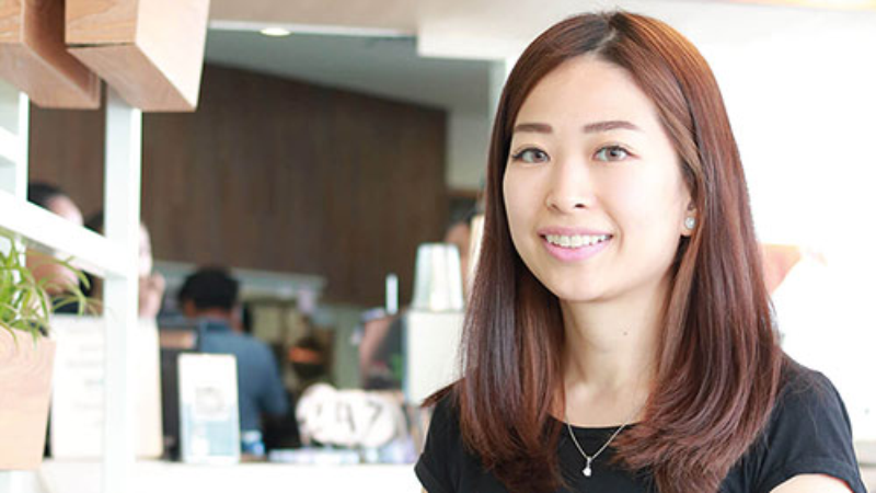 Person smiling in a bright café setting.