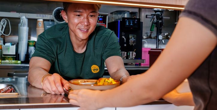2nd Generation owner Eugene Tan with his signature takeaway bowls.