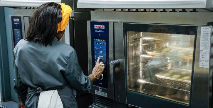 Chef setting the temperature on a RATIONAL iCombi Pro combi oven.