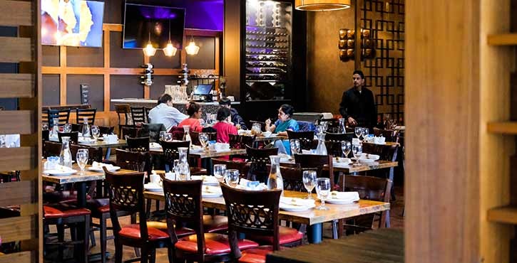 An interior view of the restaurant with diners at tables, attentive staff, and a cozy atmosphere.