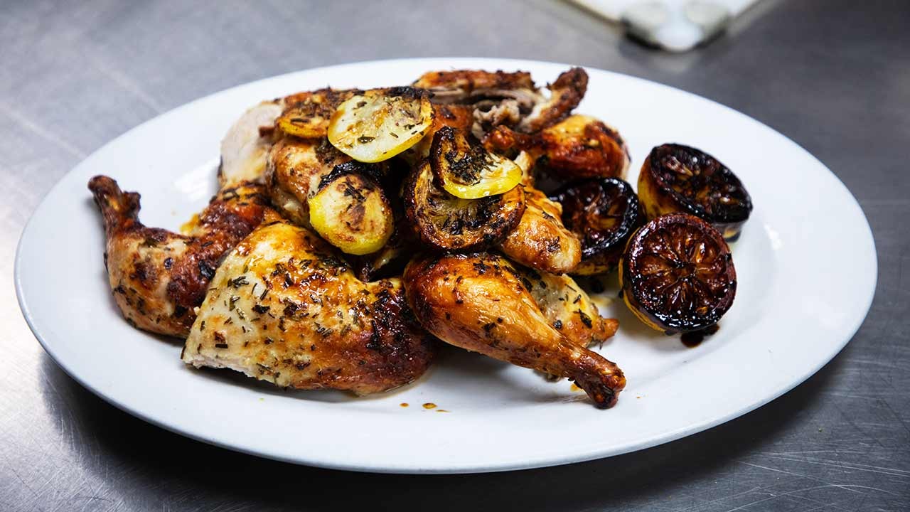 A beautifully plated dish featuring roasted chicken garnished with lemon slices.