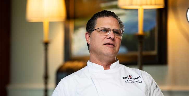 Executive chef in white jacket speaking during an interview.