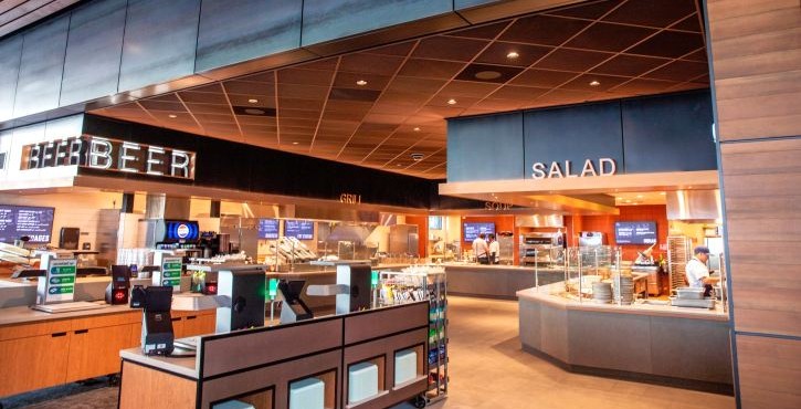 Modern cafeteria counter with beer and salad stations in a contemporary food hall.