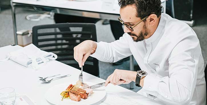Juge dégustant du porc avec légumes lors d’un concours culinaire RATIONAL.