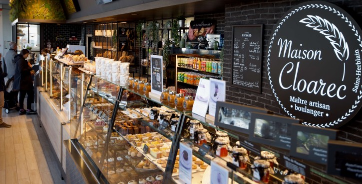 Comptoir de boulangerie chez Maison Cloarec avec viennoiseries, pains et clients en attente.