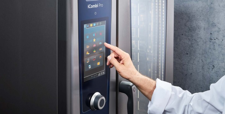 A chef is using the intelligent touchscreen display on the iCombi Pro oven.