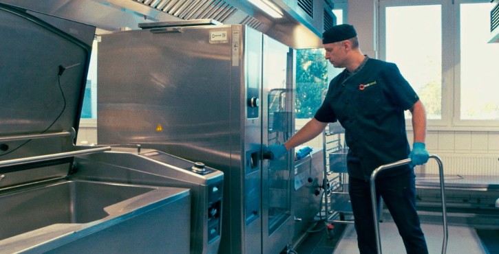 Chef working with a RATIONAL iVario Pro and RATIONAL iCombi Pro combi oven in a professional kitchen.