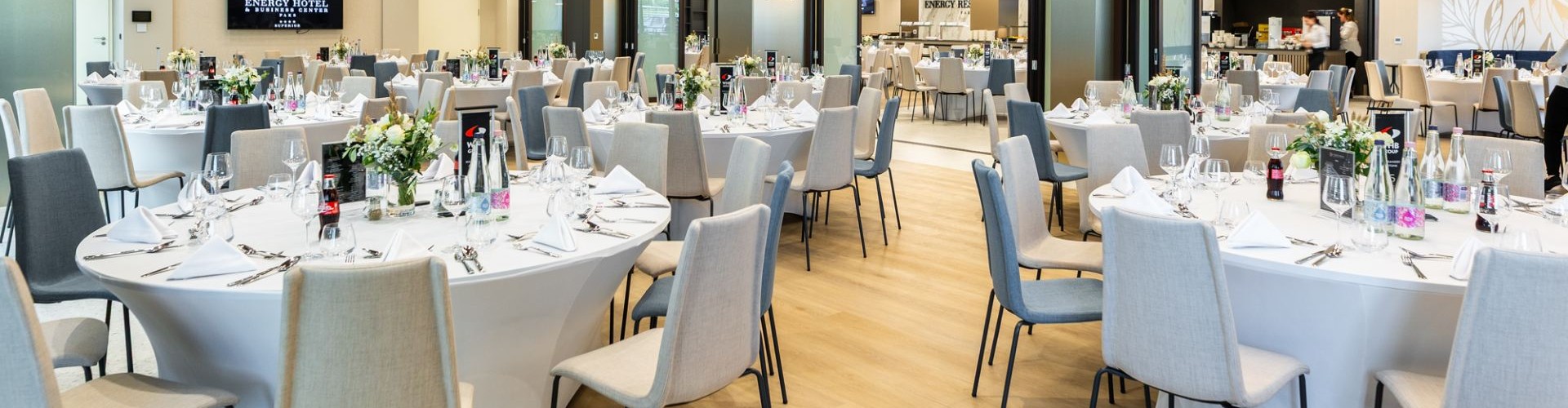 Modern hotel conference room with round banquet tables and elegant table settings.