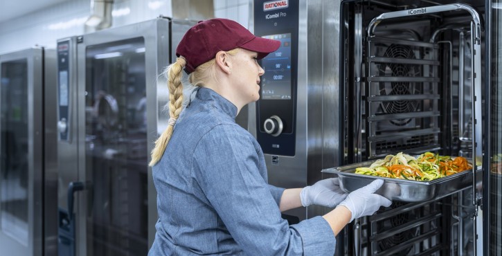 Chef loading vegetables into RATIONAL iCombi Pro combi oven.