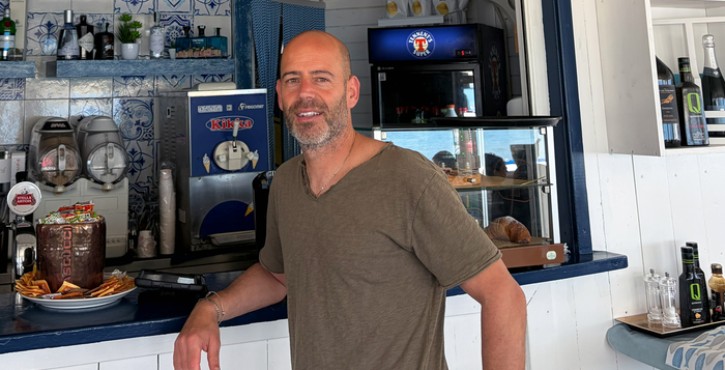 Uomo al bar del Bazzano Beach Sperlonga in un ristorante sul mare.