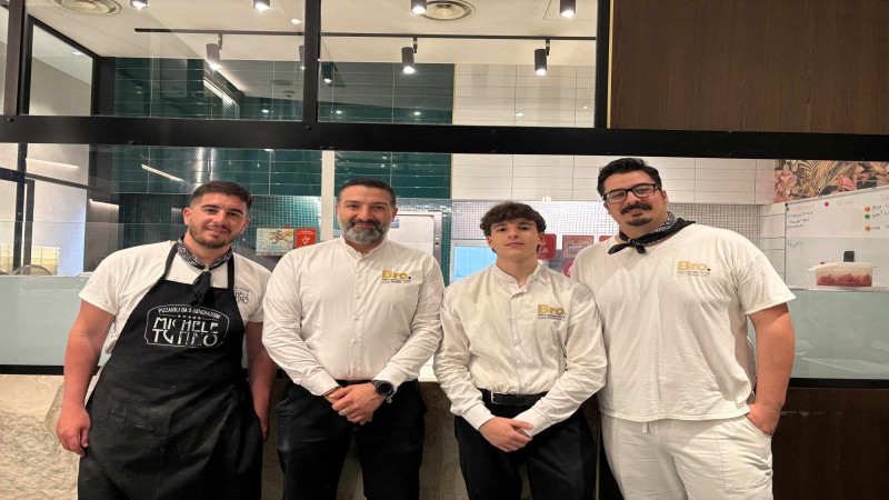 Quattro membri dello staff del ristorante posano insieme nella cucina della pizzeria Bro.
