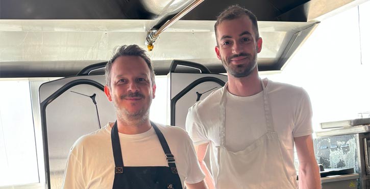 Due chef posano in una cucina professionale davanti ai sistemi di cottura RATIONAL iVario.