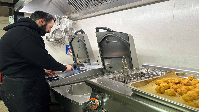Chef utilizza RATIONAL iVario Pro per preparare antipasti fritti in una cucina professionale.