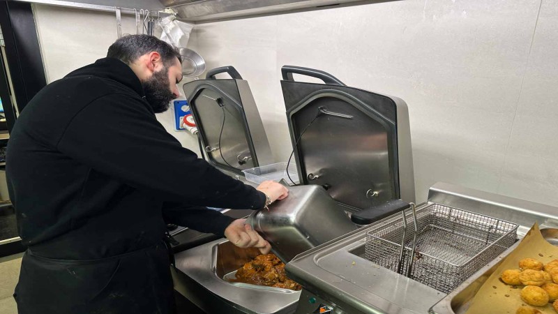 Chef trasferisce carne brasata dal RATIONAL iVario Pro a una vaschetta gastronorm in cucina professionale.