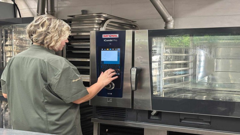 Chef utilizza il touchscreen di un RATIONAL iCombi Pro forno professionale in una cucina professionale.