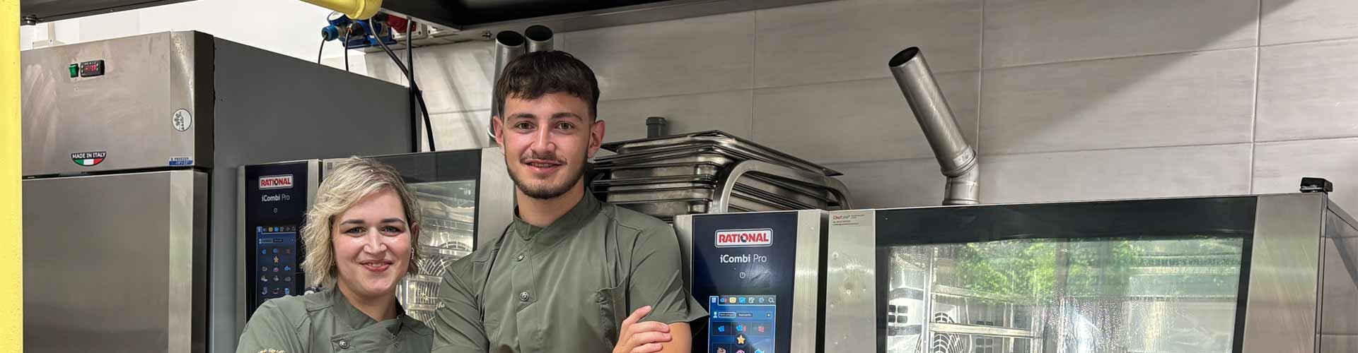 Due membri dello staff accanto a forni RATIONAL iCombi Pro forno professionale in una cucina professionale.