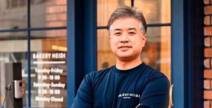 Bakery Heidiの店舗前で腕を組んで立つオーナー。