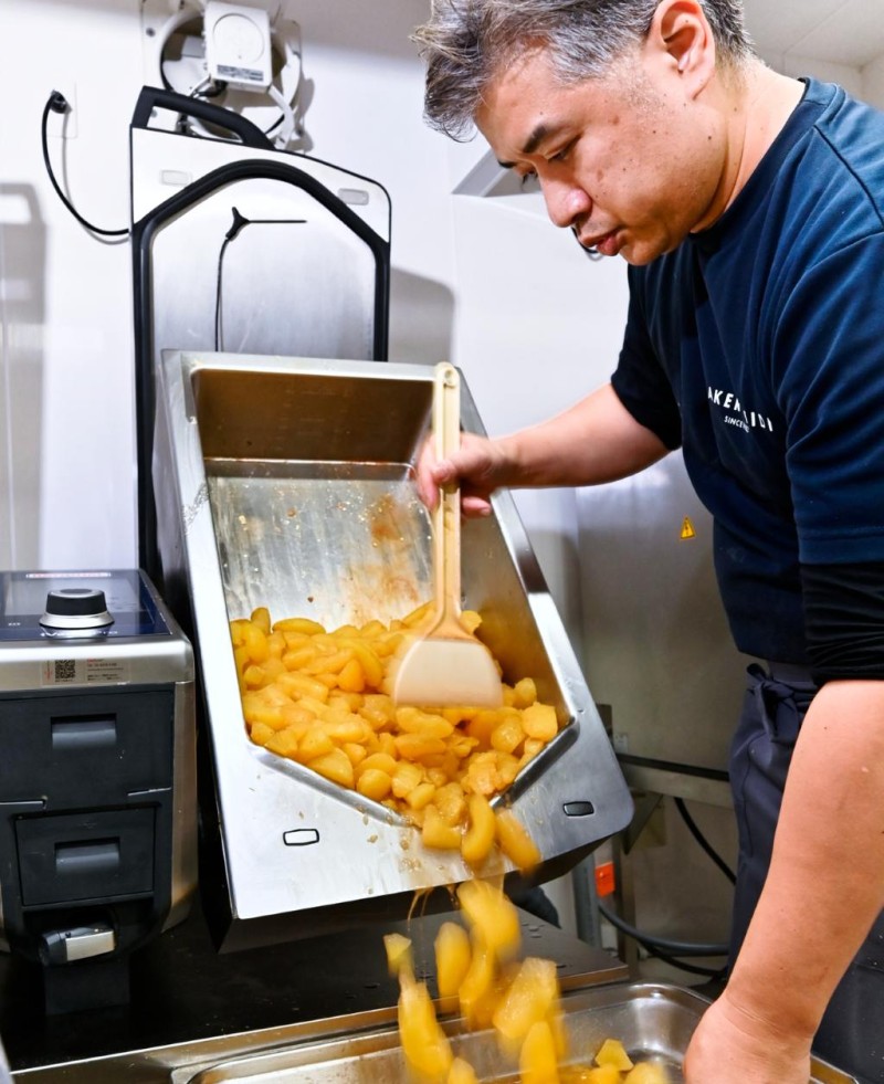 RATIONAL iVario Proから煮りんごを取り出しトレーに移すベーカリー職人。