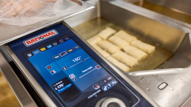Porcje potraw smażą się w RATIONAL iVario Pro z ekranem dotykowym ustawionym na 180°C.