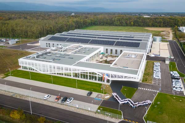 フランス・ヴィッテンハイムのRATIONAL工場の空撮、屋上にソーラーパネル、外に集まる従業員。