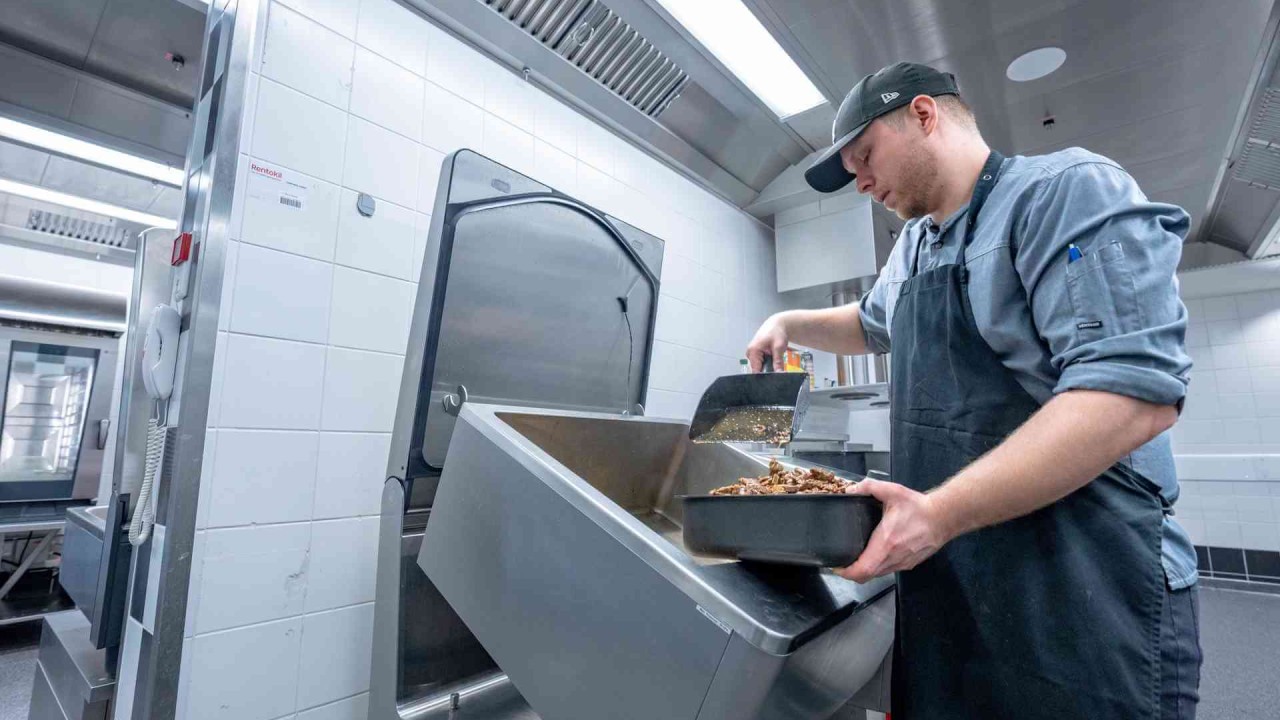 Koch gibt gebratene Pilze in den RATIONAL iVario Pro.