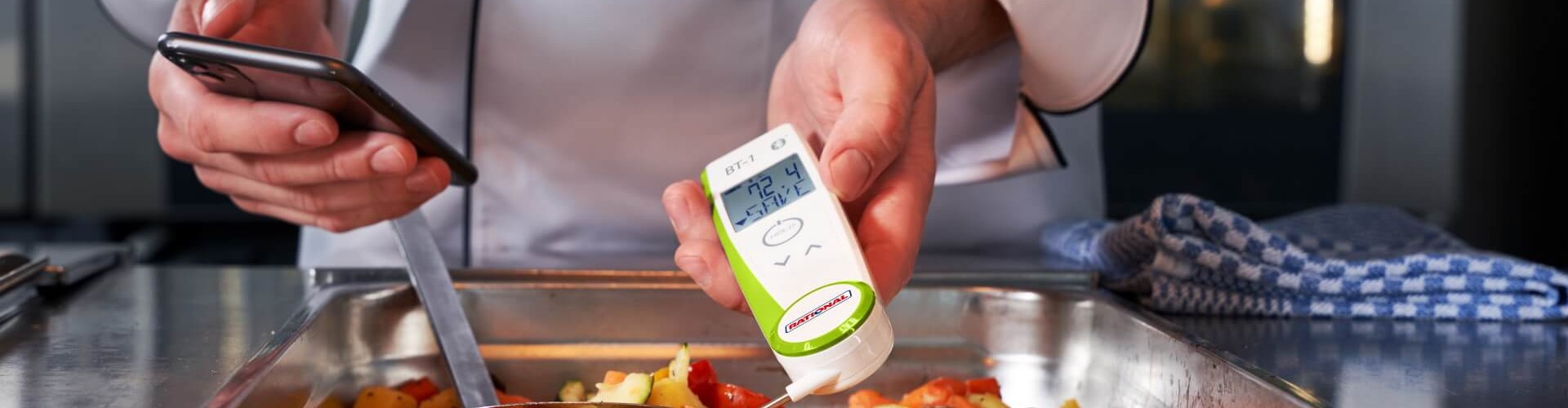 Koch prüft die Temperatur von Gemüse mit RATIONAL Thermometer und Smartphone.